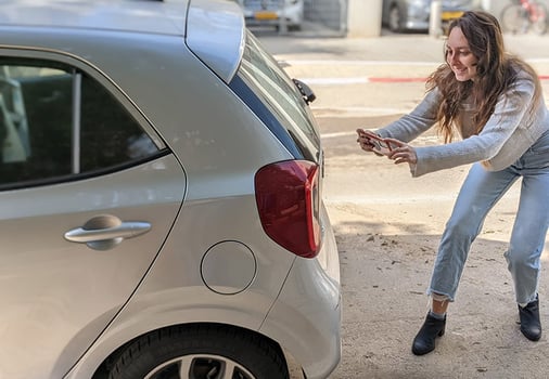 עמר פרי, מנהלת מוצר ברייבין AI מצלמת את הרכב בעזרת האפליקציה החדשה להערכת נזק, צילום: רייבין AI